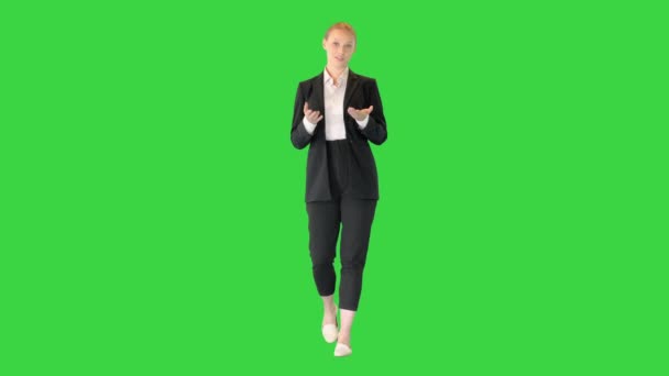 Jonge zakenvrouw praat iets uit te leggen tijdens het lopen op een groen scherm, Chroma Key. — Stockvideo