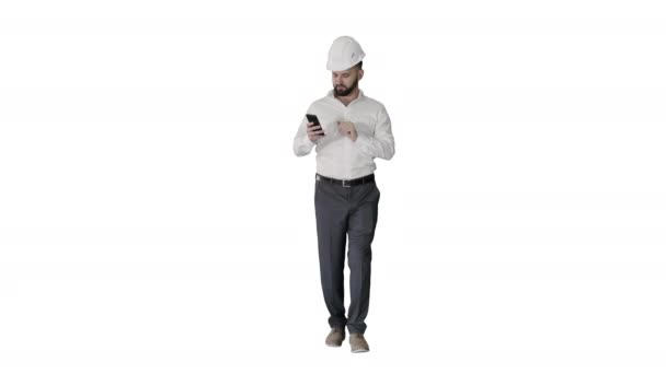 Ingeniero caminando y usando smartphone sobre fondo blanco. — Vídeos de Stock