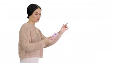Güzel, güler yüzlü bir kadın beyaz arka planda yürürken selfie çekiyor.