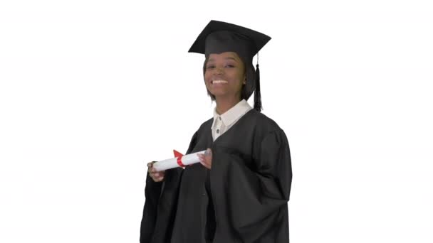 Χαμογελώντας Αφρο-Αμερικανίδα φοιτήτρια με στολή αποφοίτησης ποζάροντας με δίπλωμα σε λευκό φόντο. — Αρχείο Βίντεο