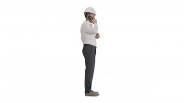 Beyaz şapkalı mühendis beyaz arka planda cep telefonuyla konuşuyor..