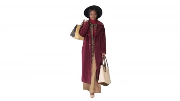 Pretty African amerykański moda dziewczyna w płaszcz i czarny kapelusz spacery z torby na zakupy na białym tle. — Wideo stockowe