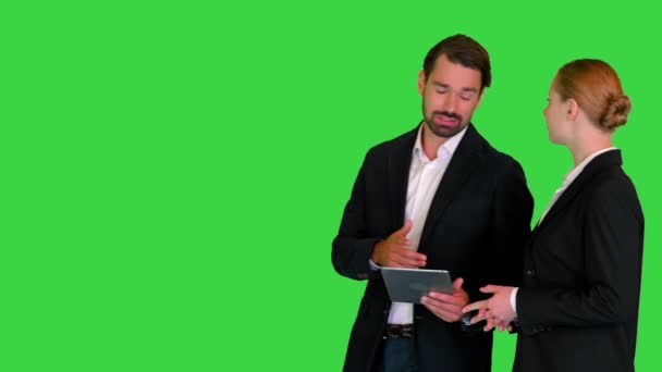 Two business partners walking using tab and talking to each other on a Green Screen, Chroma Key. — Stock Video