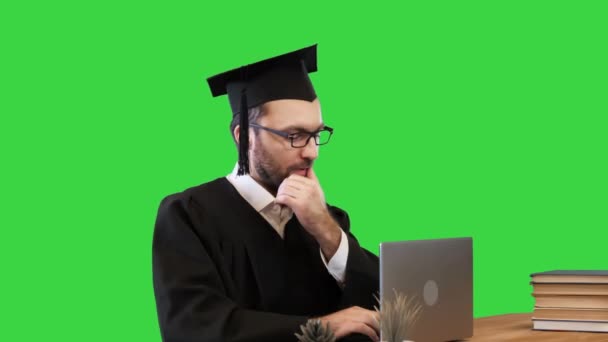 Grave estudante de graduação usando um laptop em uma tela verde, Chroma Key. — Vídeo de Stock