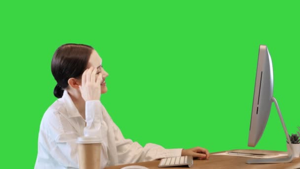 笑顔の女の子学生で机の上に座ってキッチンでウェブセミナーやオンラインコースを見ますモニター上の緑の画面,クロマキー. — ストック動画