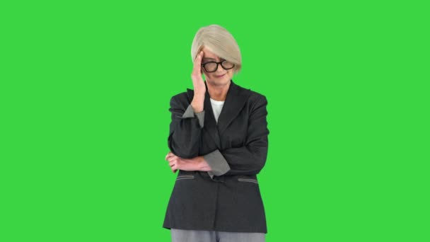 Mujer mayor de cabello gris con ropa formal que sufre de dolor de cabeza en una pantalla verde, Chroma Key. — Vídeos de Stock