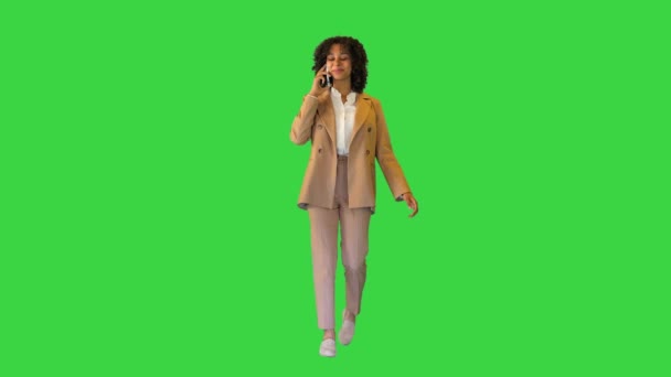 Ευτυχισμένη Αφρο-Αμερικανίδα κυρία που περπατάει και μιλάει στο τηλέφωνο σε μια πράσινη οθόνη, Chroma Key. — Αρχείο Βίντεο