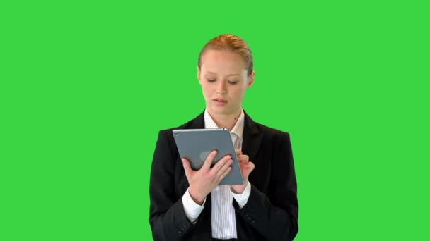 Beautiful young business woman walking and using digital tablet on a Green Screen, Chroma Key. — Stock Video