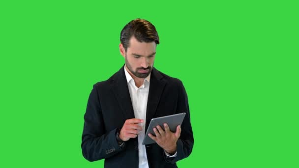 Joven hombre de negocios que trabaja con la tableta digital en una pantalla verde, Chroma Key. — Vídeo de stock