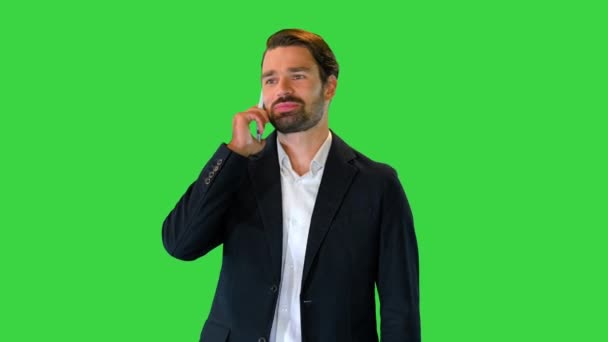 Obchodník kráčí vpřed, zatímco mluví po telefonu na zelené obrazovce, Chroma Key. — Stock video