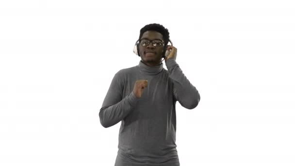 Smiling African american man in headphone and moving to the music rhythm on white background. — Stok Video