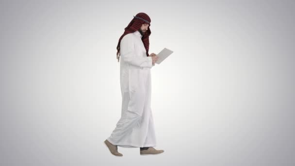 Sheikh za pomocą tabletu cyfrowego i chodzenie na gradientowym tle. — Wideo stockowe