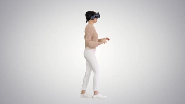 Söt ung kvinna promenader och använda interaktiva VR headset på lutning bakgrund. — Stockvideo