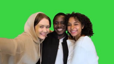 Üç mutlu melez arkadaş yeşil ekranda selfie çekiyorlar, Chroma Key..