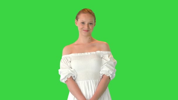 緑の画面上でカメラにポーズをとる白いドレスの美しい女性,クロマキー. — ストック動画
