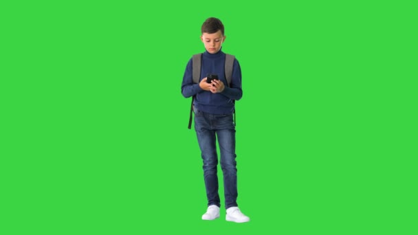 그린 스크린에서 휴대 전화를 사용하여 가방을 사용하는 학생 크로마 키. — 비디오