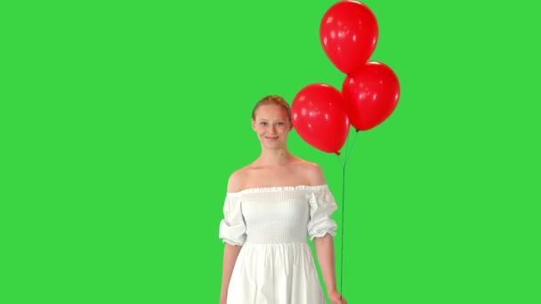 Χαμογελαστή νεαρή γυναίκα φορώντας λευκό φόρεμα με μπαλόνια σε μια πράσινη οθόνη, Chroma Key. — Αρχείο Βίντεο