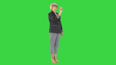 Yeşil Ekran, Chroma Key 'deki sanal ekranın düğmelerini gösteren gözlüklü kıdemli iş kadını..