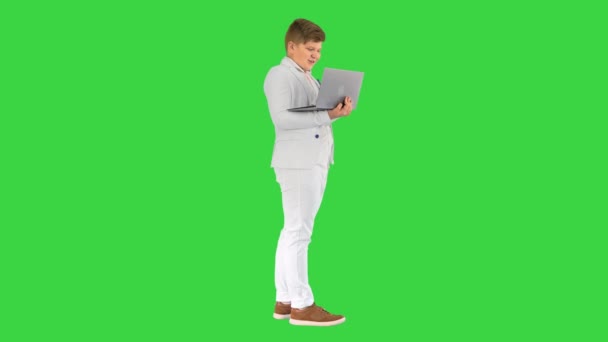 緑の画面に勝利のジェスチャーを作るラップトップを持つ幸せな少年,クロマキー. — ストック動画