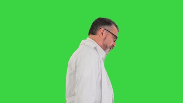 Smutny lekarz w okularach chodzący po zielonym ekranie, Chroma Key. — Wideo stockowe