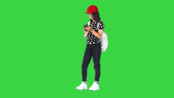 Junges Mädchen mit Rucksack und Smartphone auf grünem Bildschirm, Chroma Key. — Stockvideo