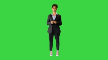 Genç siyahi bayan kamerada konuşuyor ve yeşil ekranda bir şeyi işaret ediyor, Chroma Key..