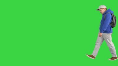 Yakışıklı okul çocuğu yeşil ekranda müzik dinlerken yanından geçiyor, Chroma Key.