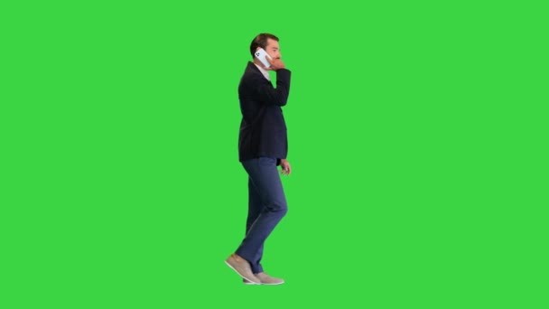 Бизнесмен идет вперед, разговаривая по телефону на зеленом экране, Chroma Key. — стоковое видео