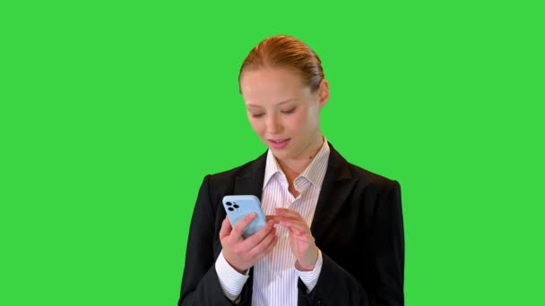 Усміхнена бізнесменка стоїть і користується мобільним телефоном на зеленому екрані, Chroma Key. — стокове відео