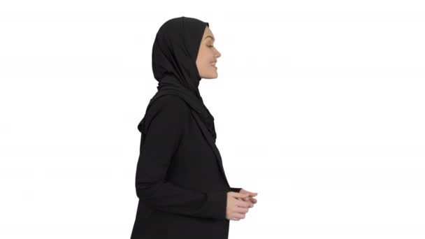 Leende arabiska kvinna bär hijab talar om affärer medan promenader och gester på vit bakgrund. — Stockvideo