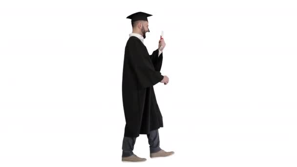 Estudiante graduado caminando y levantando su sombrero sobre fondo blanco. — Vídeos de Stock