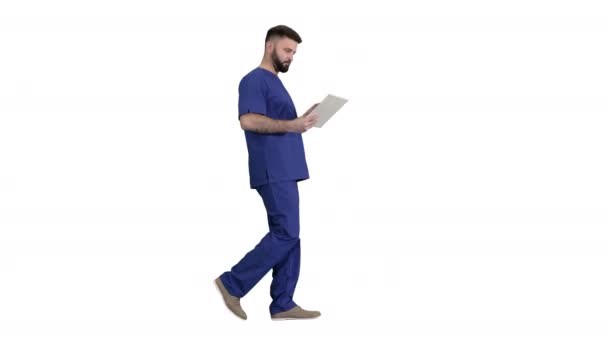 Selbstbewusst konzentrierter Chirurg mit digitalem Tablet auf weißem Hintergrund. — Stockvideo