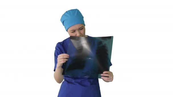 Tänkande kvinnlig läkare i uniform undersöka en bröstkorgen röntgen på vit bakgrund. — Stockvideo