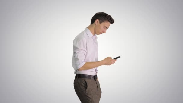 Man i vit skjorta promenader med mobiltelefon på lutning bakgrund. — Stockvideo