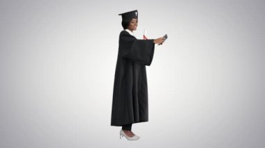Mutlu Afrikalı Amerikalı kadın mezunlar diploma taşıyor ve arka planda selfie çekiyor..