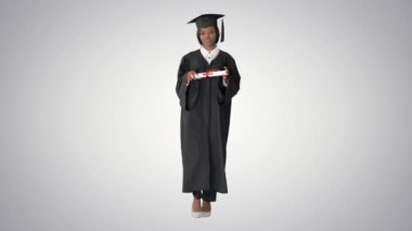 Ciddi Afrika kökenli Amerikalı kadın mezun. Eğilimli arka planda diplomayla yürüyor..
