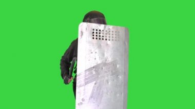 Çevik kuvvet, çevik kuvvet kalkanına yeşil ekran Chroma Key sopasıyla vururken gürültü yapıyor..