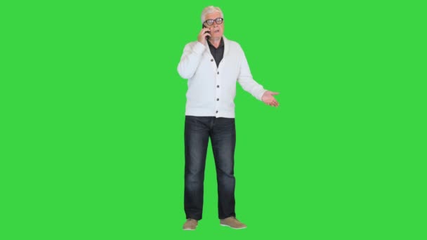 Boos senior man maakt een oproep op een groen scherm, Chroma Key. — Stockvideo