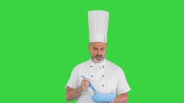 Aşçı aşçı elinde kase ve kırbaçla Yeşil Ekranda yemek hazırlıyor, Chroma Key.