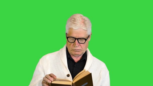 Старший чоловік читає книжку на зеленому екрані, Chroma Key. — стокове відео