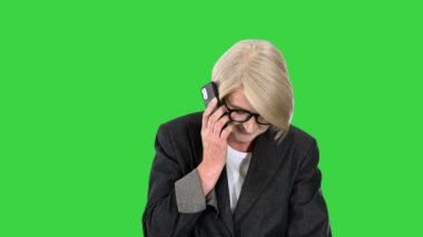 Kıdemli iş kadını yeşil ekranda yürürken telefon ediyor, Chroma Key..