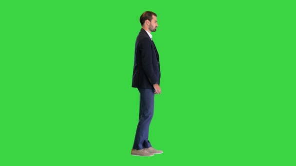 緑色の画面に何かを提示する仮想ボタンを押すスーツのハンサムな男,クロマキー. — ストック動画