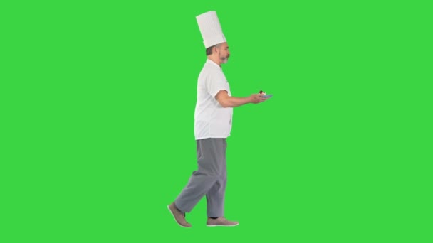 Pasticcere maschile che cammina veloce con il dessert in mano su uno schermo verde, Chroma Key. — Video Stock