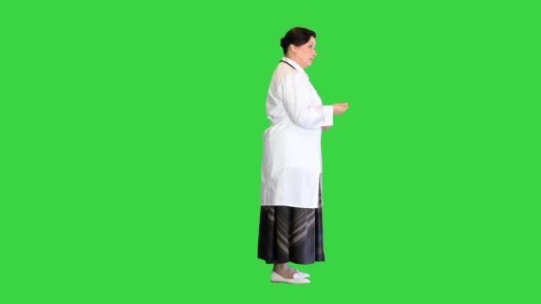 Dojrzała lekarz rozmawia z kimś na zielonym ekranie, Chroma Key. — Wideo stockowe