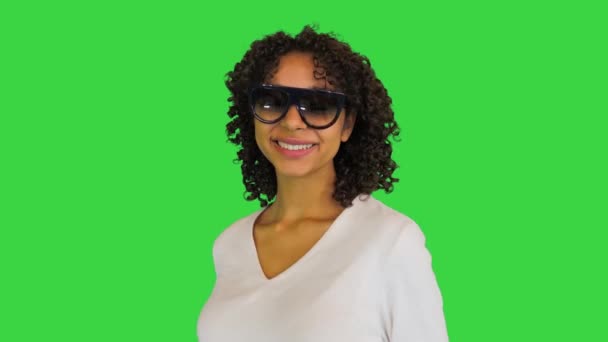 Bella signora afroamericana sorride guardando sopra gli occhiali da sole su uno schermo verde, Chroma Key. — Video Stock