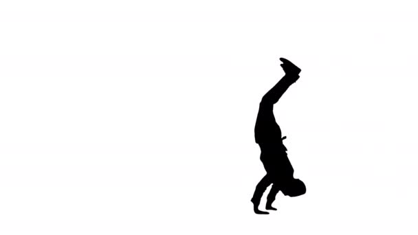 Silhouette Male chef cook in red uniform doing somersaults and hand spins looking at camera. — Stock Video