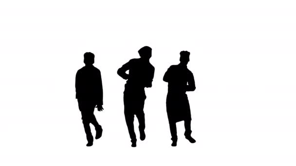 Silhouet Drie grappige chef koks in rood uniform dansen tegen groene achtergrond. — Stockvideo