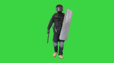 Zırhlı ağır bir polis, kalkanı ve bastonu var. Yeşil Ekran 'da yürüyor, Chroma Key..