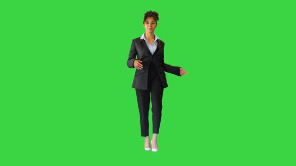 Νεαρό σγουρό κορίτσι της Αφρικής σε ένα κοστούμι με τα πόδια και μιλώντας στην κάμερα σε μια πράσινη οθόνη, Chroma Key. — Αρχείο Βίντεο