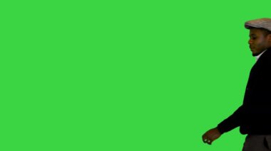 Yeşil Ekranda yürüyen şapkalı yakışıklı siyah adam, Chroma Key.